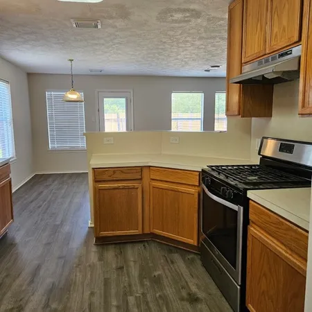 a kitchen with wooden cabinets and stainless steel appliances
