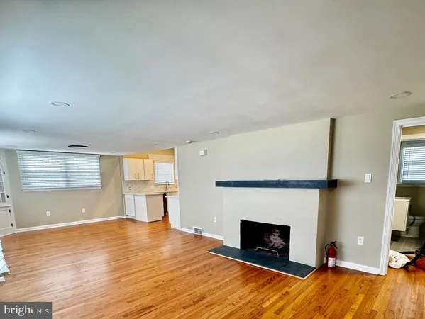 a view of empty room with a fireplace and wooden floor