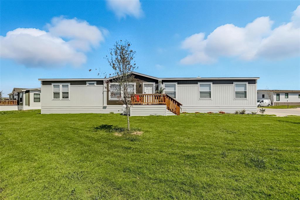 Rear view of property featuring a yard and a deck