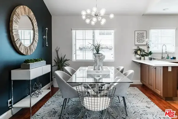 a view of a dining room with furniture a chandelier and a window