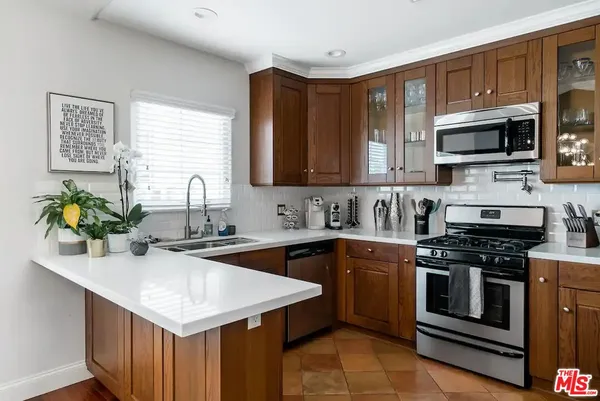 a kitchen with stainless steel appliances granite countertop a sink stove and microwave
