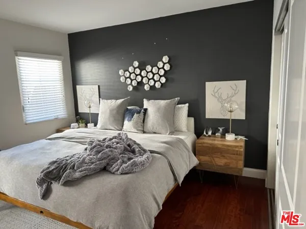 a bedroom with a bed and a lamp on dresser