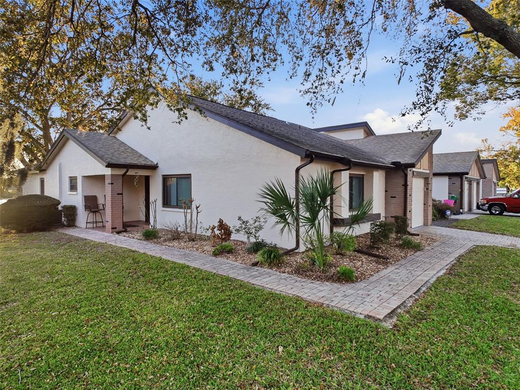 7406 Heather Walk Drive Weeki Wachee, FL 34613 - Photo 14 of 49 a front view of a house with garden and patio