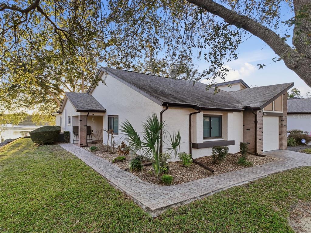 7406 Heather Walk Drive Weeki Wachee, FL 34613 - Photo 2 of 49 a front view of a house with garden