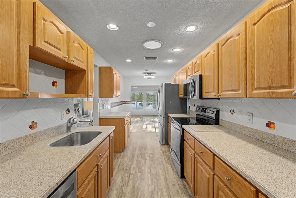 7406 Heather Walk Drive Weeki Wachee, FL 34613 - Photo 36 of 49 a kitchen with a sink a counter top space stainless steel appliances and cabinets