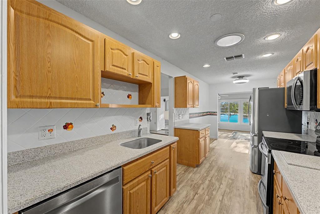 7406 Heather Walk Drive Weeki Wachee, FL 34613 - Photo 37 of 49 a kitchen with lots of counter space and wooden floor