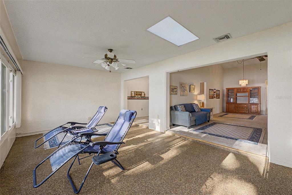 7406 Heather Walk Drive Weeki Wachee, FL 34613 - Photo 38 of 49 a living room with furniture and a chandelier