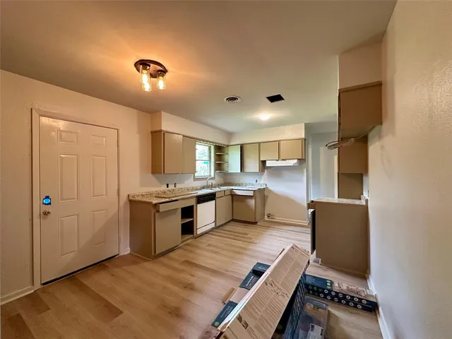 a kitchen with stainless steel appliances granite countertop a refrigerator a stove and a sink