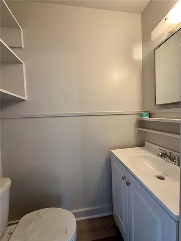 a bathroom with a toilet a sink and mirror