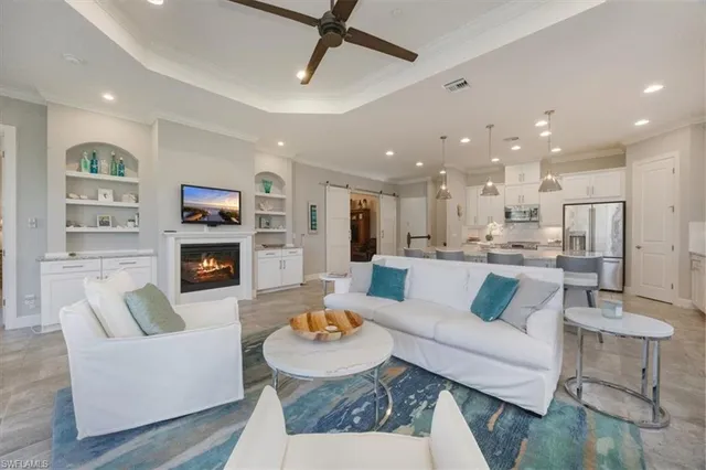 a living room with fireplace furniture and a view of kitchen
