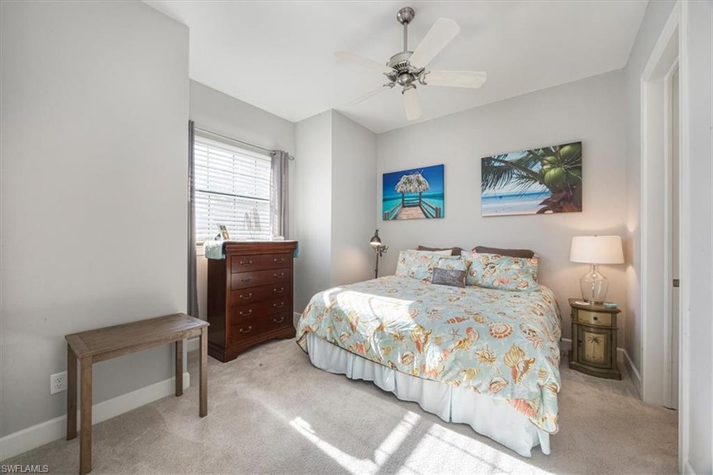 8773 Bellano Court, Unit 201 Naples, FL 34119 - Photo 11 of 34 a bedroom with a bed and a desk