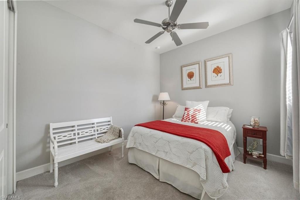 8773 Bellano Court, Unit 201 Naples, FL 34119 - Photo 13 of 34 a bedroom with a bed and a chandelier