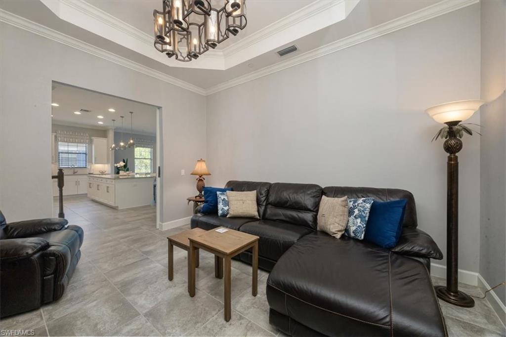 8773 Bellano Court, Unit 201 Naples, FL 34119 - Photo 15 of 34 a living room with furniture and a chandelier