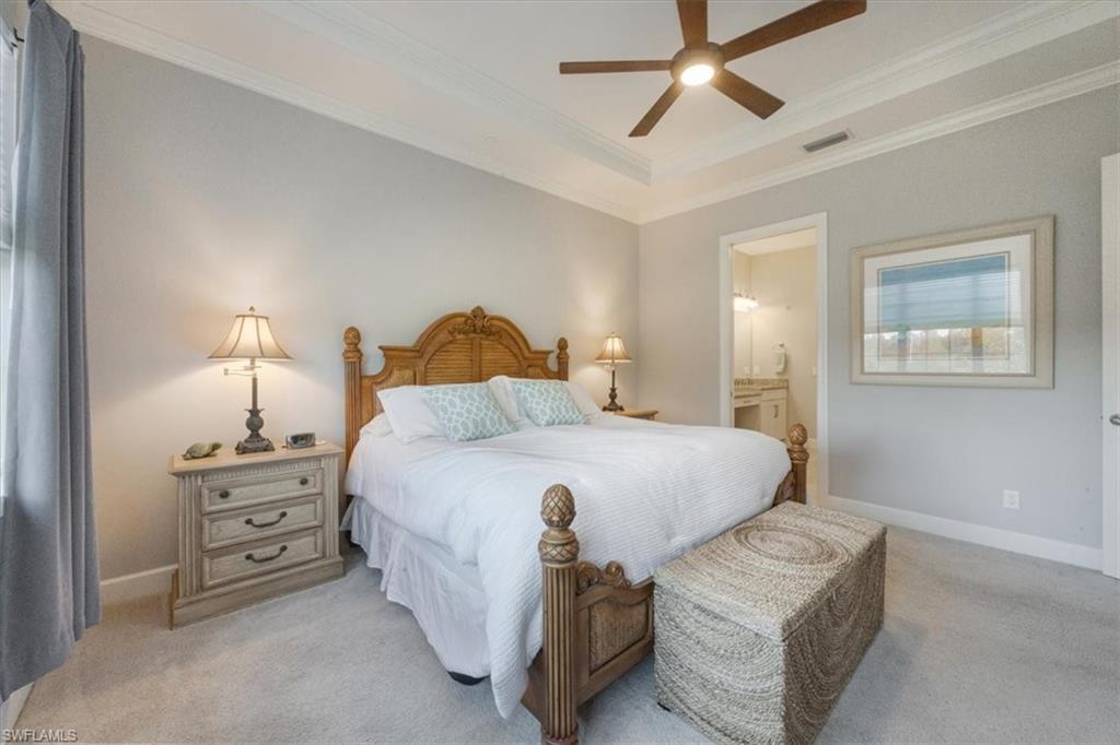 8773 Bellano Court, Unit 201 Naples, FL 34119 - Photo 17 of 34 a bedroom with a bed and a chandelier