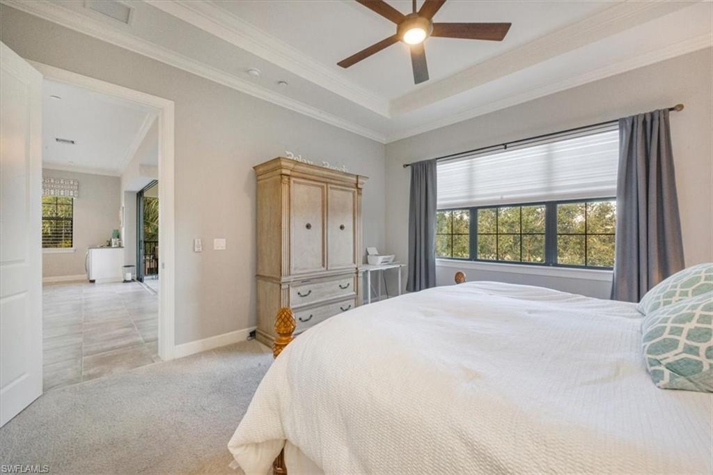 8773 Bellano Court, Unit 201 Naples, FL 34119 - Photo 19 of 34 a bedroom with a large bed and a chandelier