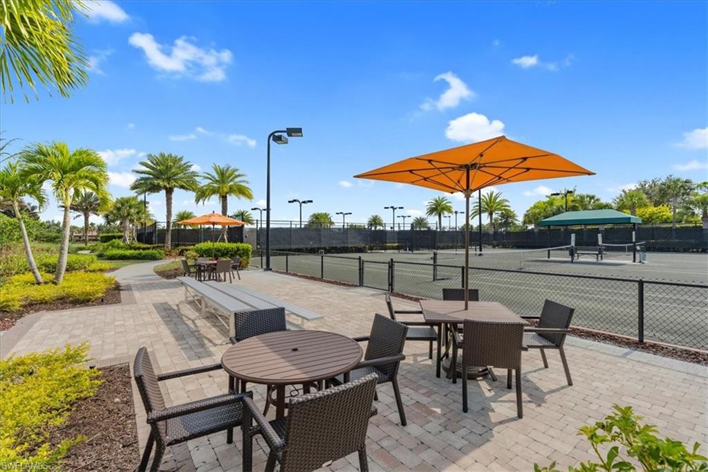 8773 Bellano Court, Unit 201 Naples, FL 34119 - Photo 30 of 34 a view of a patio with a table and chairs under an umbrella