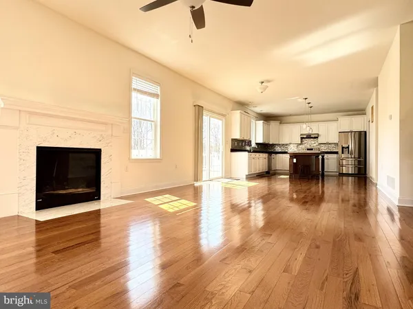 a view of a living room with hardwood floor and a fireplace