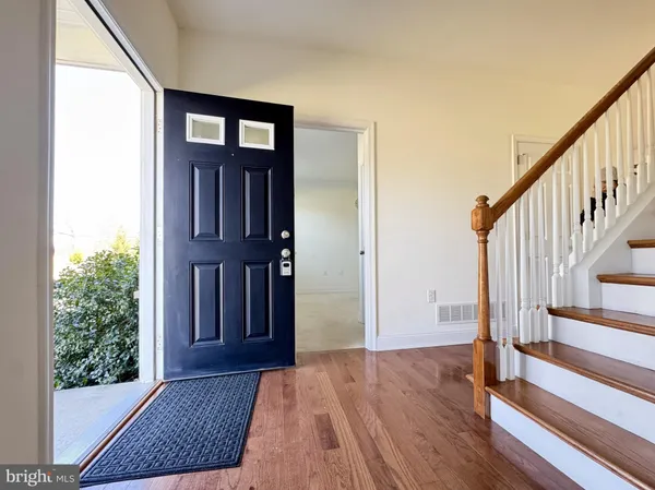 a view of a hallway with wooden floor and stairs
