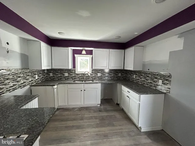 a kitchen with granite countertop a sink and cabinets