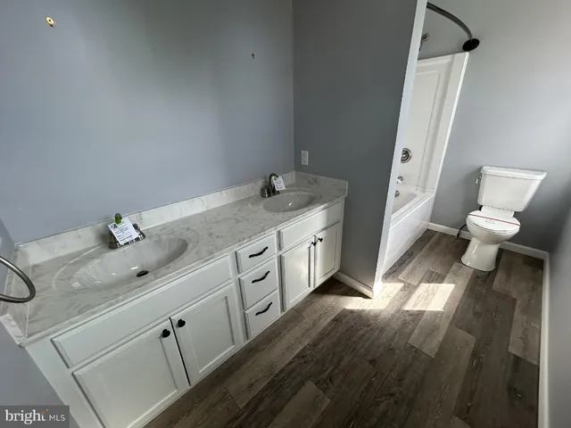 a spacious bathroom with a granite countertop sink toilet and a mirror