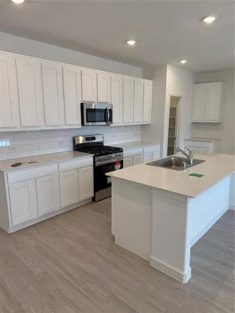 a kitchen with a sink stove and cabinets