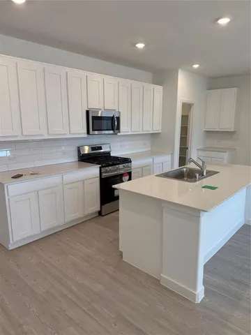 a kitchen with a sink stove and cabinets