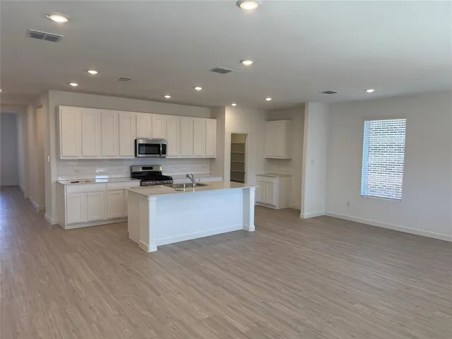 a kitchen with a refrigerator and white cabinets