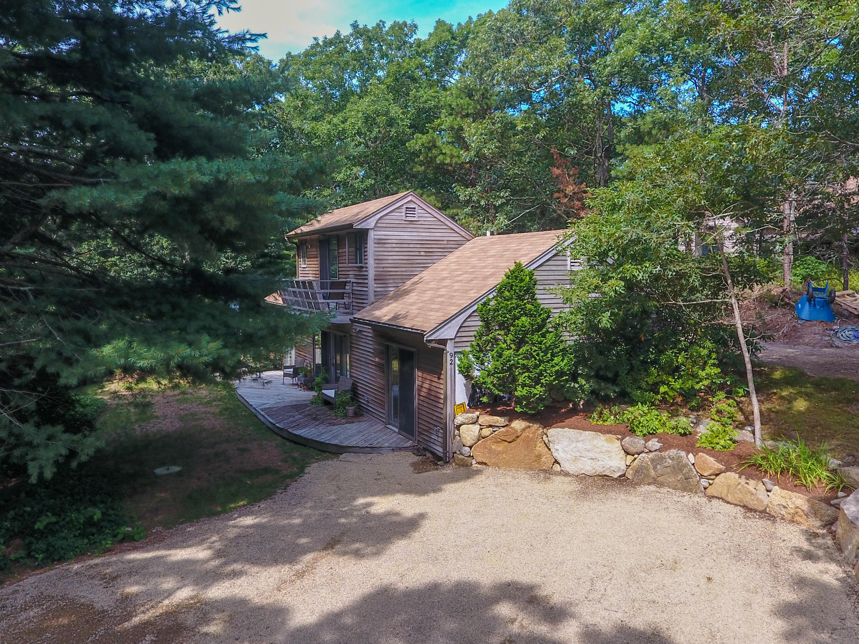 92 Springhill Road Vineyard Haven, MA 02568 - Photo 6 of 38 a view of a wooden house with a yard and large trees