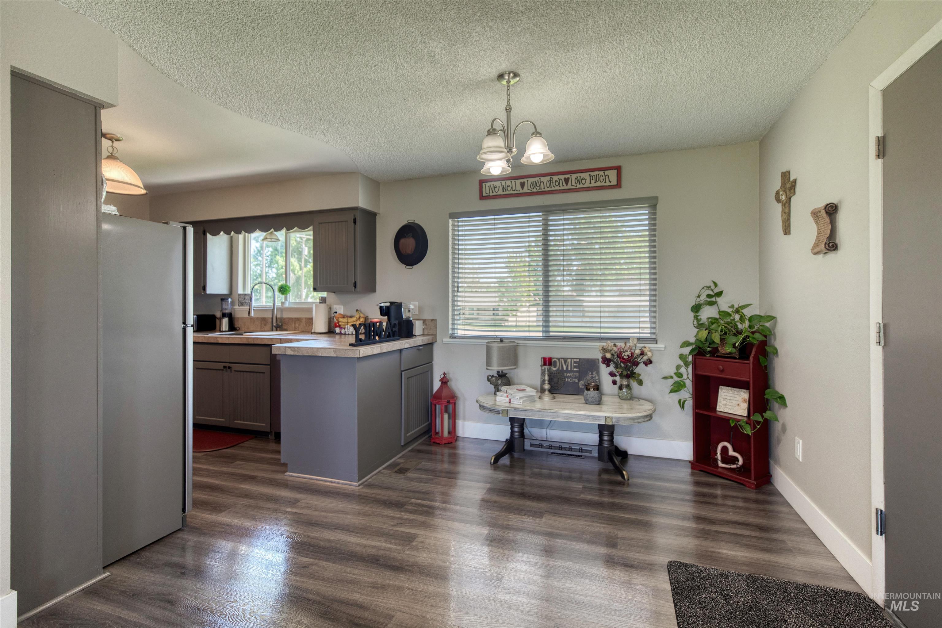 20803 Friends Road Greenleaf, ID 83626 - Photo 5 of 39 Open-concept kitchen and dining area featuring wood-finish flooring, shaker-style cabinetry, and a double-basin sink