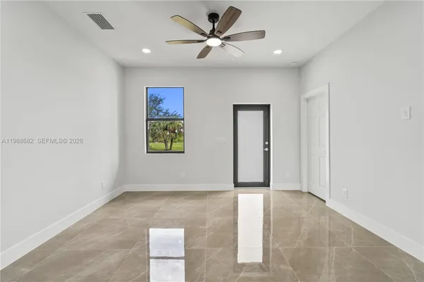 an empty room with fan and windows