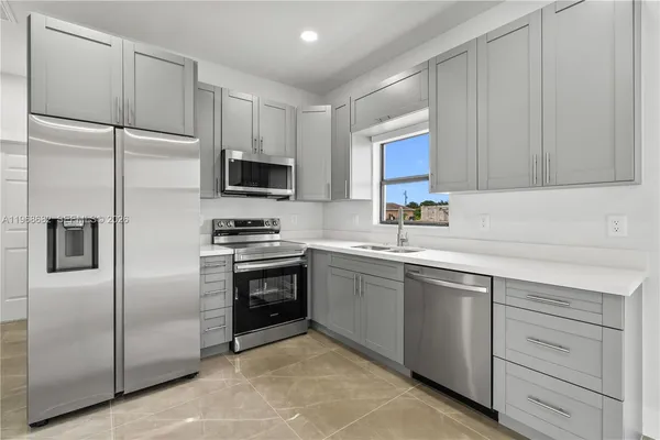 a kitchen with cabinets stainless steel appliances and a sink