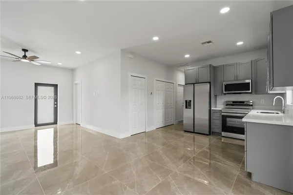 a view of kitchen with stainless steel appliances a refrigerator and cabinets