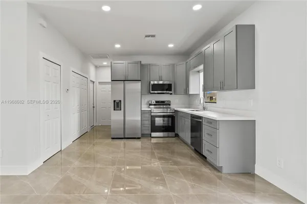 a large kitchen with cabinets and stainless steel appliances