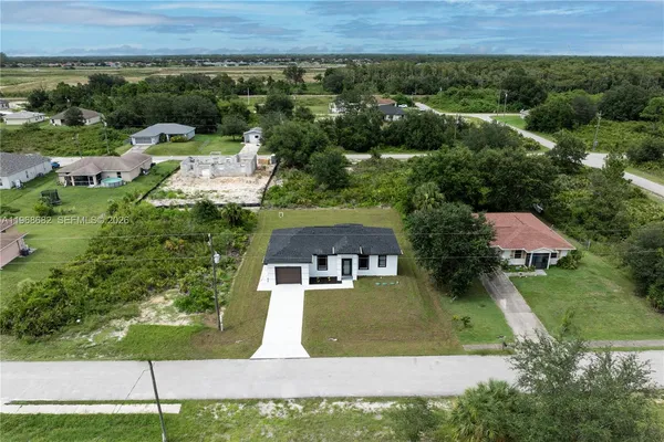 an aerial view of a house with a yard and lake view