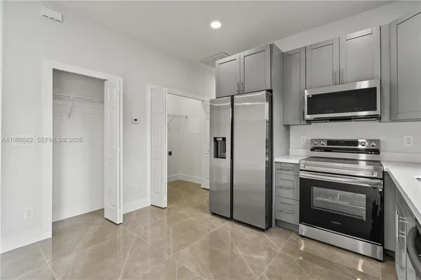 a kitchen with stainless steel appliances a refrigerator a stove a microwave and cabinets