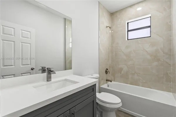 a bathroom with a sink a toilet and a large mirror