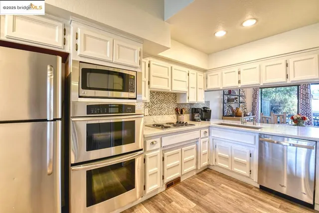 a view of a kitchen with kitchen island a large window a sink and counter space