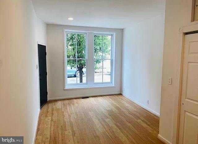 407 South 20th Street, Unit A Philadelphia, PA 19146 - Photo 2 of 14 a view of an empty room with wooden floor and a window