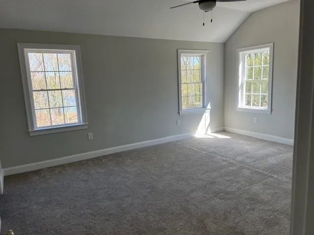 a bedroom with a large bed and windows
