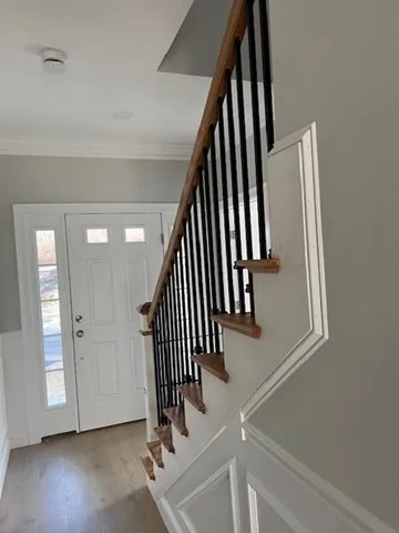 an entryway with wooden floor and stairs