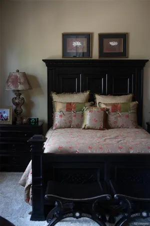 a bedroom with a bed and a lamp on dresser
