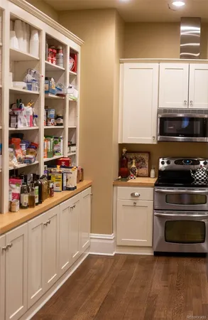 a kitchen with stainless steel appliances a stove a sink and white cabinets