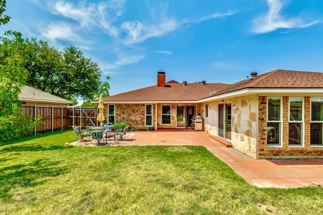 a front view of a house with a yard table and chairs