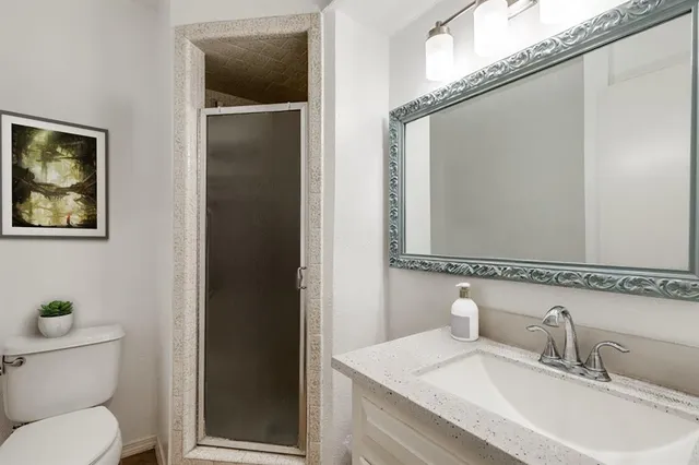 a bathroom with a granite countertop sink toilet and shower