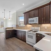 a kitchen with stainless steel appliances granite countertop wooden cabinets a stove top oven a sink and dishwasher