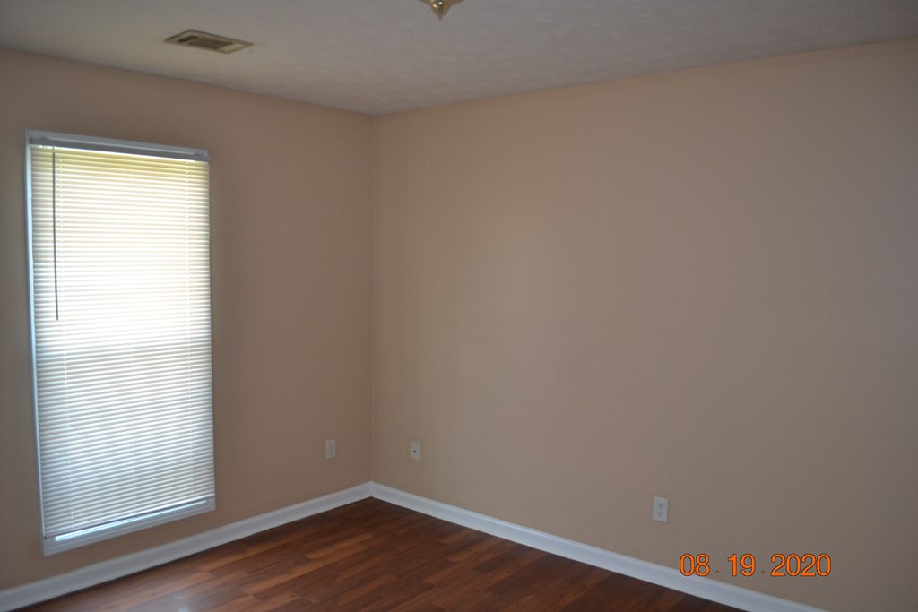 12a Crosswinds Road Phenix City, AL 36869 - Photo 8 of 21 a view of an empty room with wooden floor and a window