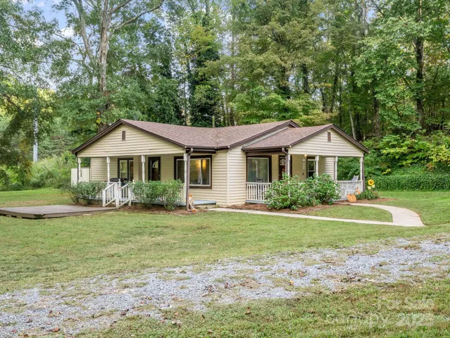 a front view of a house with a yard and trees