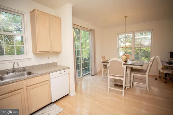 a kitchen with a dining table chairs and large windows