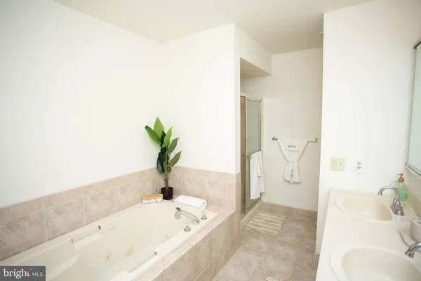 a bathroom with a tub sink and mirror