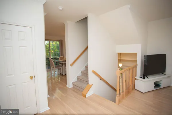 a view of a livingroom with wooden floor and staircase